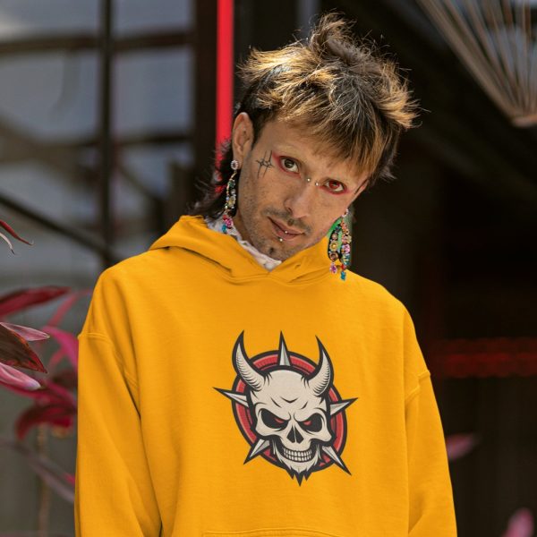 Man with piercings and red eye makeup wearing gold Devil Skull graphic hoodie