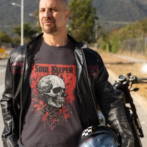 Man in black leather biker jacket wearing Soul Keeper skull T-shirt beside a motorbike